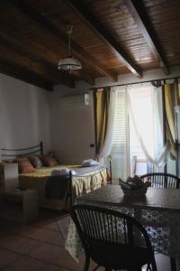 1 dormitorio con 1 cama, mesa y sillas en Mary home, en SantʼAlessio Siculo