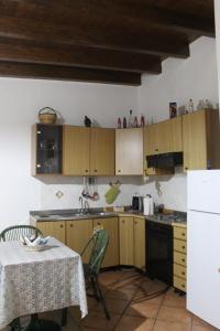 cocina con armarios de madera, mesa, mesa y sillas en Mary home, en SantʼAlessio Siculo