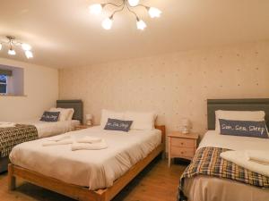 een slaapkamer met 2 bedden en een kroonluchter bij The Oast House in Weymouth