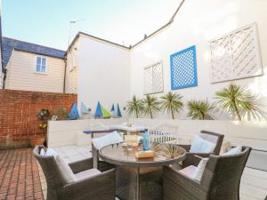 een patio met een tafel en stoelen bij The Oast House in Weymouth