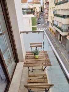 a wooden table on a balcony with a plant at APARTAMENTOS ELEMAR free luggage storage in Málaga