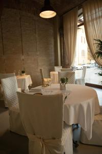 a dining room with white tables and white chairs at Locanda del vecchio mulino in Fiorano Modenese