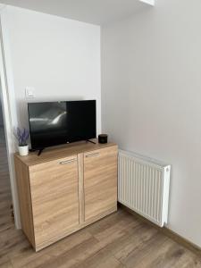 a flat screen tv sitting on top of a wooden entertainment center at Rzut beretem od gondoli in Szczyrk