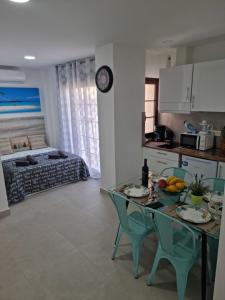 a kitchen and living room with a table and chairs at APARTAMENTOS ELEMAR free luggage storage in Málaga