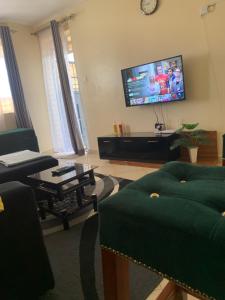 a living room with a couch and a tv at Vee's Homestay, Nakuru Town in Nakuru