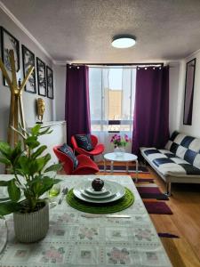 un soggiorno con divano e tavolo di Cómodo departamento en bellas artes con vista privilegiada a Santiago