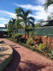 une passerelle en brique rouge avec des palmiers et un pont dans l'établissement Stargazer Private Pool, à Zambales