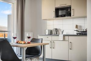 デンツリンゲンにあるEmpire Living: Denzlingen Marktplatzのワイングラス2つが置かれたテーブルのあるキッチン