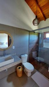 a bathroom with a toilet and a sink and a mirror at Aldeia Biribiri - Pousada in Caraíva