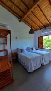 a bedroom with two beds and a window at Aldeia Biribiri - Pousada in Caraíva