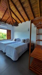 sypialnia z 2 łóżkami i drewnianym sufitem w obiekcie Aldeia Biribiri - Pousada w mieście Caraíva