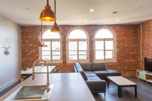 cocina y sala de estar con pared de ladrillo en Les Lofts du Trésor - Par Les Lofts Vieux-Québec, en Quebec