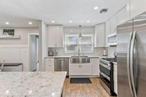 a kitchen with white cabinets and a stainless steel refrigerator at Naperville Nest-Dog Friendly Cozy North Naperville 3 BED/2 BA Home in Naperville