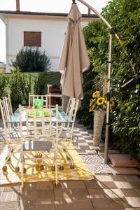 una mesa, sillas y una sombrilla en el patio en Borgo Nuovo Housing en Fucecchio