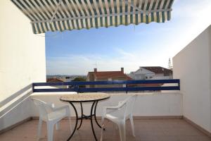 d'une table et de chaises sur un balcon avec vue. dans l'établissement Ocean Moradia com vista para a vila, à São Martinho do Porto