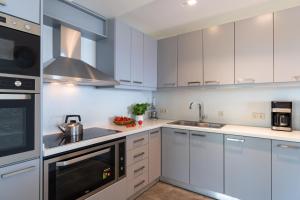a kitchen with white cabinets and a sink at Seaside Private Beach Paradise in Kos