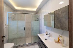 a bathroom with a shower and a sink at Seaside Private Beach Paradise in Kos