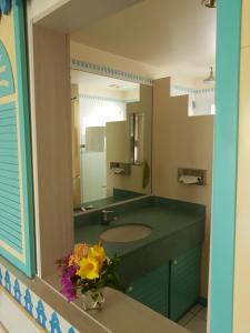 un bagno con un lavandino e un grande specchio di Studio CRISTAL COCO Martinique a Les Trois-Îlets