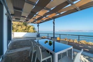 a patio with a table and chairs and a view of the ocean at Seaside Private Beach Paradise in Kos +17 photos