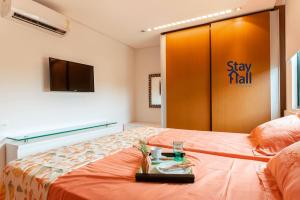 ein Hotelzimmer mit einem Bett, einem TV und einer Wand in der Unterkunft Apt Marulhos-BeiraMar Praia de Muro Alto-058M in Ipojuca + 13 Fotos