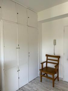 Habitación con armarios blancos y silla de madera. en Recoleta Suite Studio Profesional WIFI Museos en Buenos Aires