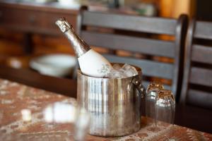 Una botella de champán en un cubo sobre una mesa en Sodwana Bay Lodge House 34 en Sodwana Bay