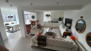 ein Wohnzimmer mit zwei Sofas und einem Tisch in der Unterkunft Weekend Poolhouse Sarajevo in Miševići