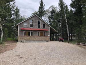 a house sitting on top of a gravel driveway at Heated Floors, Hot Tub, Grill in Island Park