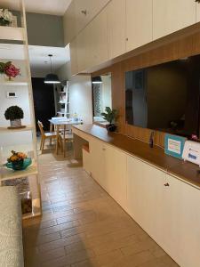 a kitchen with white cabinets and a dining room at Modern and Cozy Studio near Airport Terminal 3 in Manila