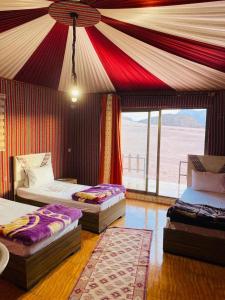 a room with three beds and a tent at The sunset of Wadi Rum in Wadi Rum