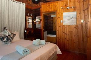 Sodwana Bay Lodge House 34 في سودوانا باي: غرفة نوم بسريرين عليها مناشف