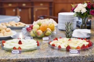 einen Tisch mit Kuchen und Obst auf Platten in der Unterkunft Map Hotel in Lages