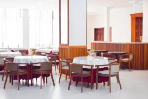 a dining room with white tables and chairs at Map Hotel in Lages