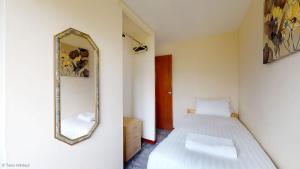 a bedroom with a bed and a mirror on the wall at 39 Strawberry Hill, Tolroy Manor in Hayle