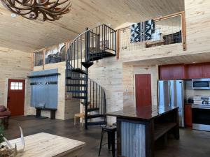 a living room with a spiral staircase in a house at Newly Built, Fire Pit, Kitchen in Rea