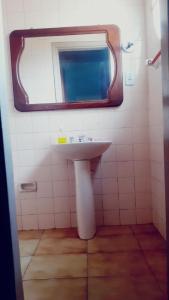 ein Bad mit einem Waschbecken und einem Spiegel in der Unterkunft Pousada 4 cantos in Corumbá