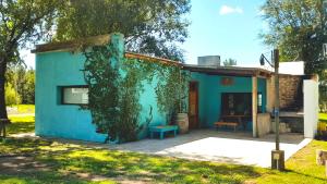 una casa azul con vides creciendo a su lado en Casa de campo en Zapiola , Lobos, Buenos Aires. en Lobos