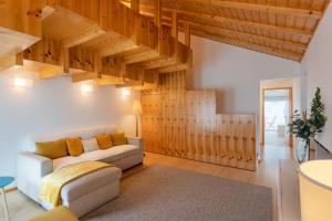 Apartamento Férias (Apartamento Norte) في كوستا نوفا: غرفة معيشة مع أريكة بيضاء وسقوف خشبية