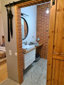 ein Badezimmer mit einem Waschbecken und einer Ziegelwand in der Unterkunft Wałowa Jak Nowa in Danzig