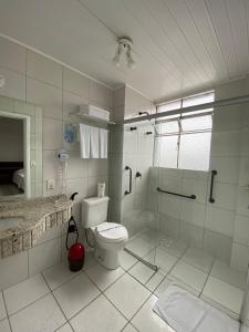 La salle de bains blanche est pourvue d'une douche et de toilettes. dans l'établissement Map Hotel, à Lages