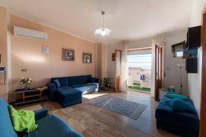 un soggiorno con divano blu e sedia blu di White Rose Suite Apartment a Cala Gonone