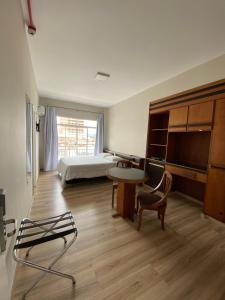 1 dormitorio con 1 cama, 1 mesa y 1 silla en Map Hotel, en Lages