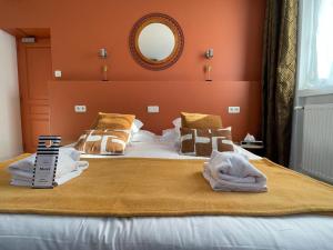 ein Schlafzimmer mit einem großen Bett mit Handtüchern darauf in der Unterkunft Hôtel Jules in Le Touquet-Paris-Plage