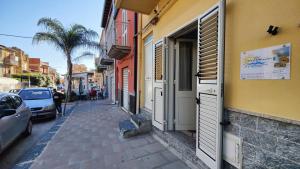 a narrow street with cars parked on the side of a building at Almiva alloggio confortevole vicino alla Scala dei Turchi in Realmonte
