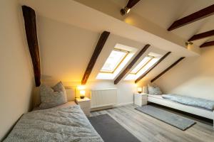 a attic bedroom with two beds and skylights at Börde-Apartment 5 in Vahldorf