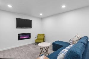 sala de estar con sofá azul y TV en Luxurious Fully Renovated House w/ New Hot Tub! en Sandy