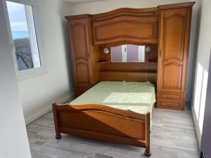 Cama de madera en habitación con ventana en Gîte des Buis, en Moutier-Rozeille