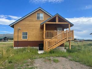 a log home with a large deck in a field at Loft, Kitchen, Washer,Dryer in Island Park