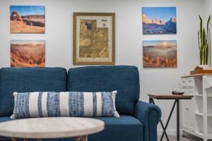 un sofá azul en una sala de estar con fotos en la pared en Luxurious Fully Renovated House w/ New Hot Tub! en Sandy