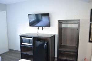 TV de pantalla plana en la parte superior de un armario en Noble Suites Jacksonville, en Jacksonville